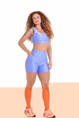 Short bicolor BFF Fitness Atacado com bolso lateral visível, mão apoiada no bolso durante o treino
